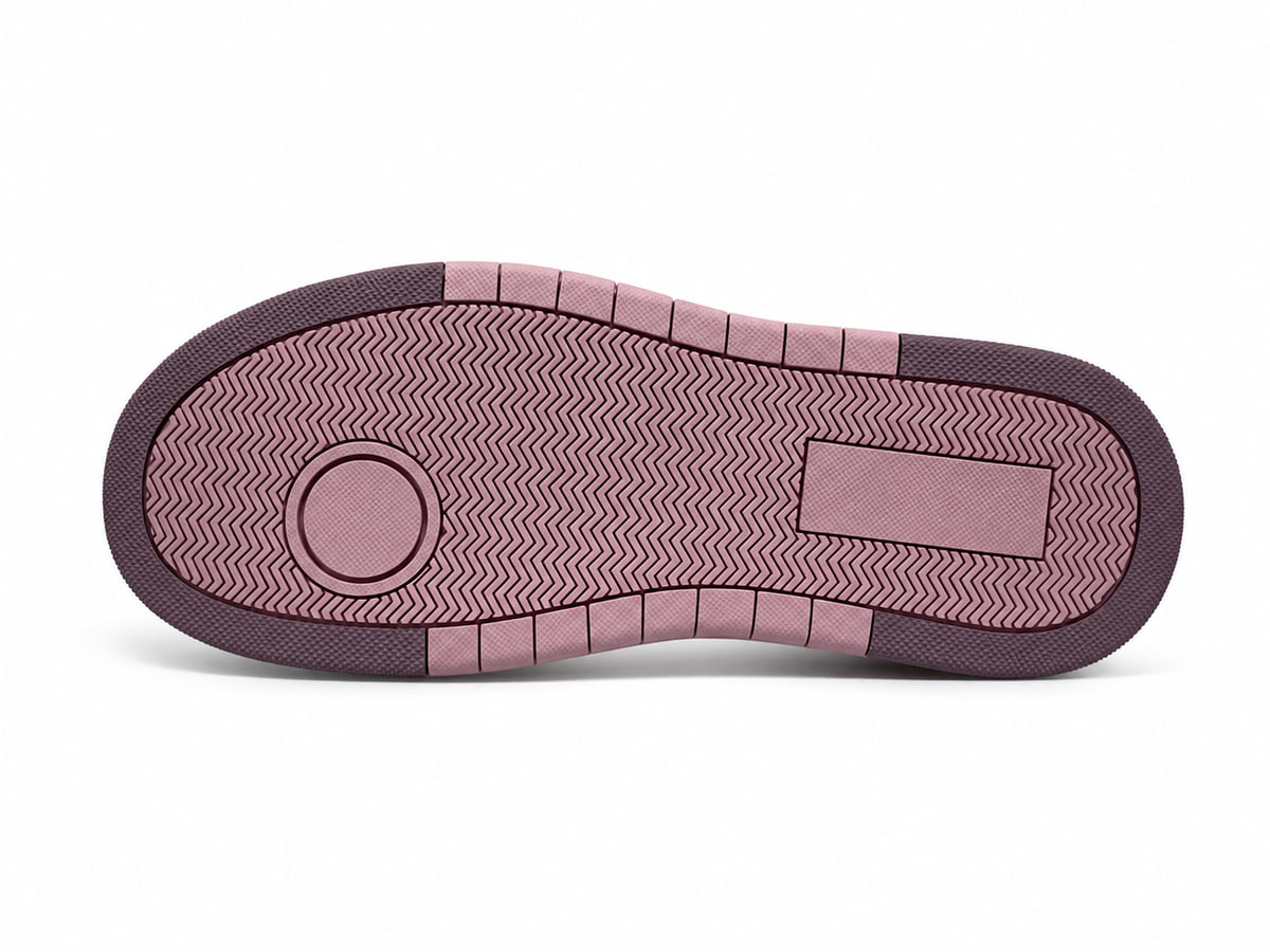 Underside of the same pink sole, with a zig-zag tread across the forefoot and a circular pivot pad